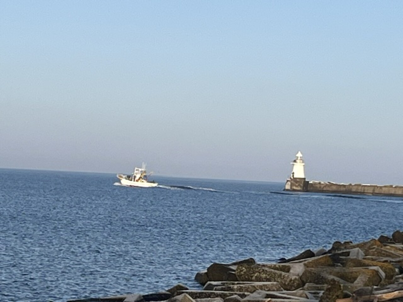 北海道・海へ出港する船と灯台